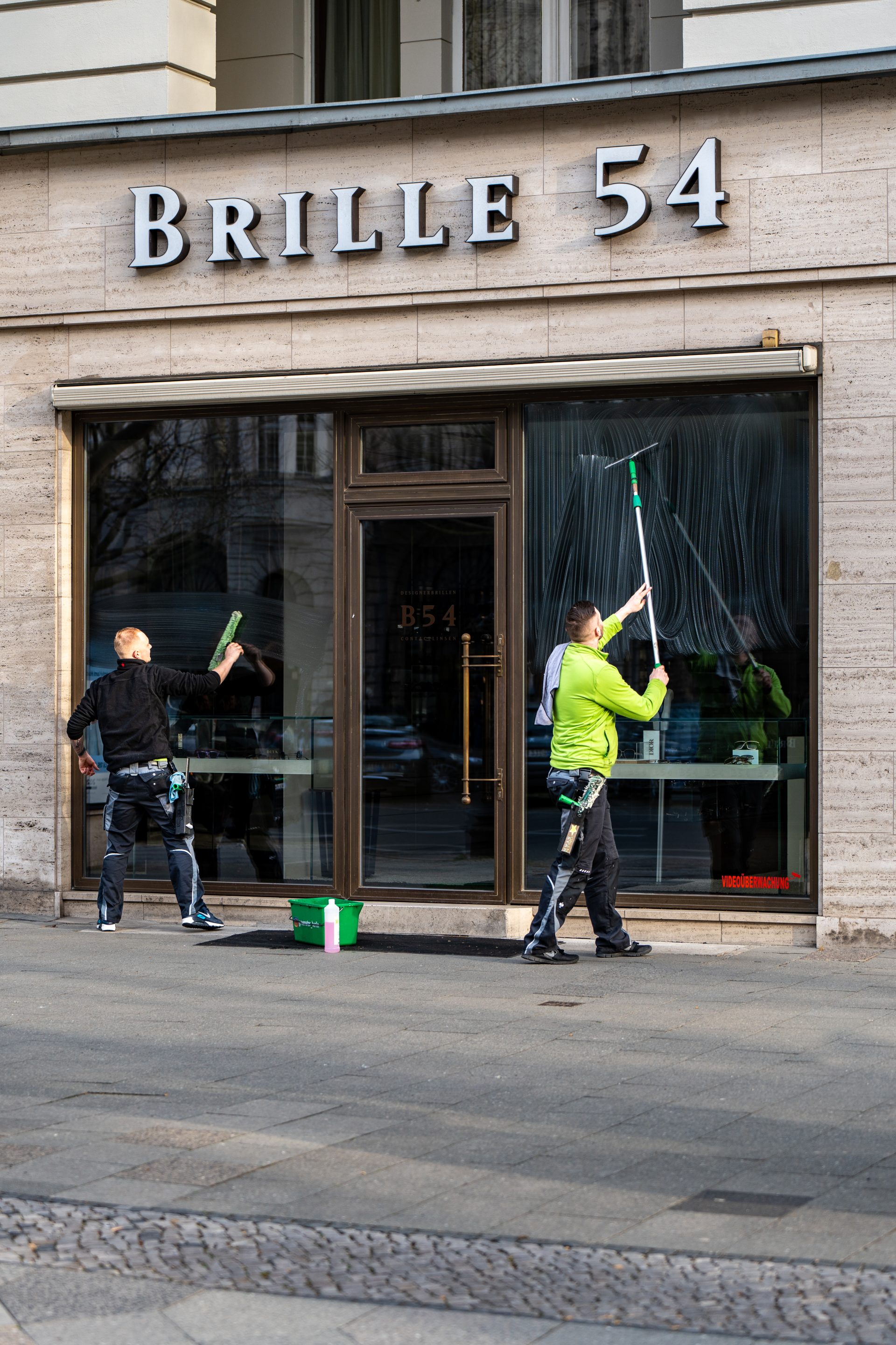 Mitarbeiter der Green Star GmbH reinigt Schaufenster